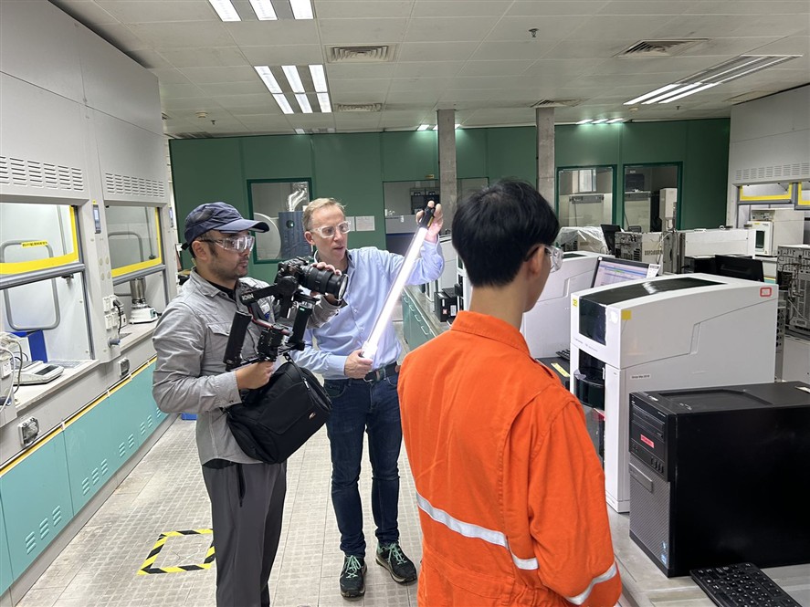 Production coordinator and camera crew working inside an industrial environment in Shenzhen