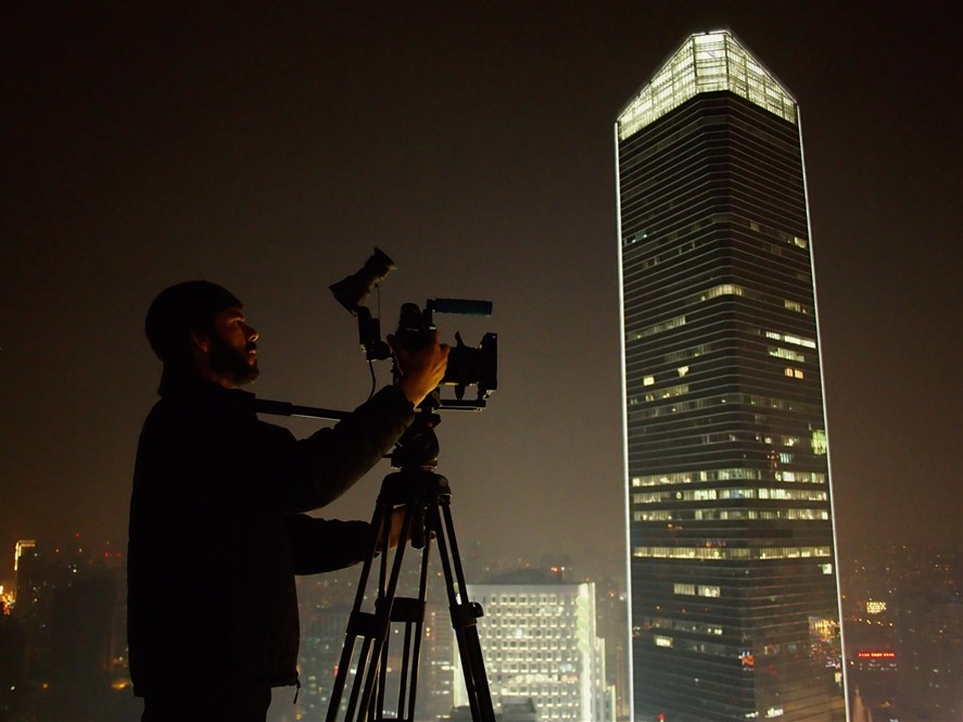 Camera operator filming a skyline scene at night in Shenzhen